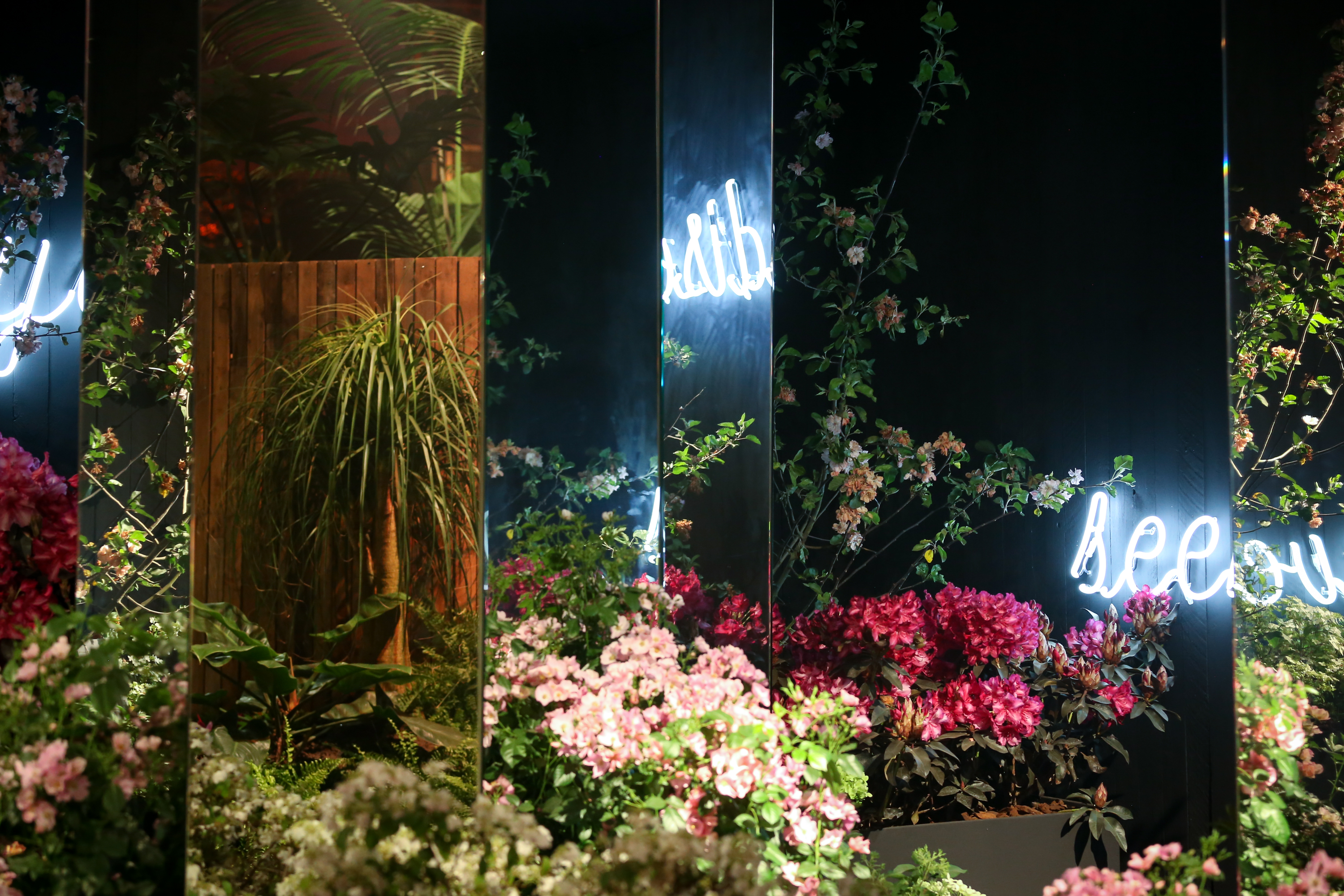 Nocturne Floraliën Gand 2022 Image d'œuvres florales avec texte en néon visible dans les miroirs